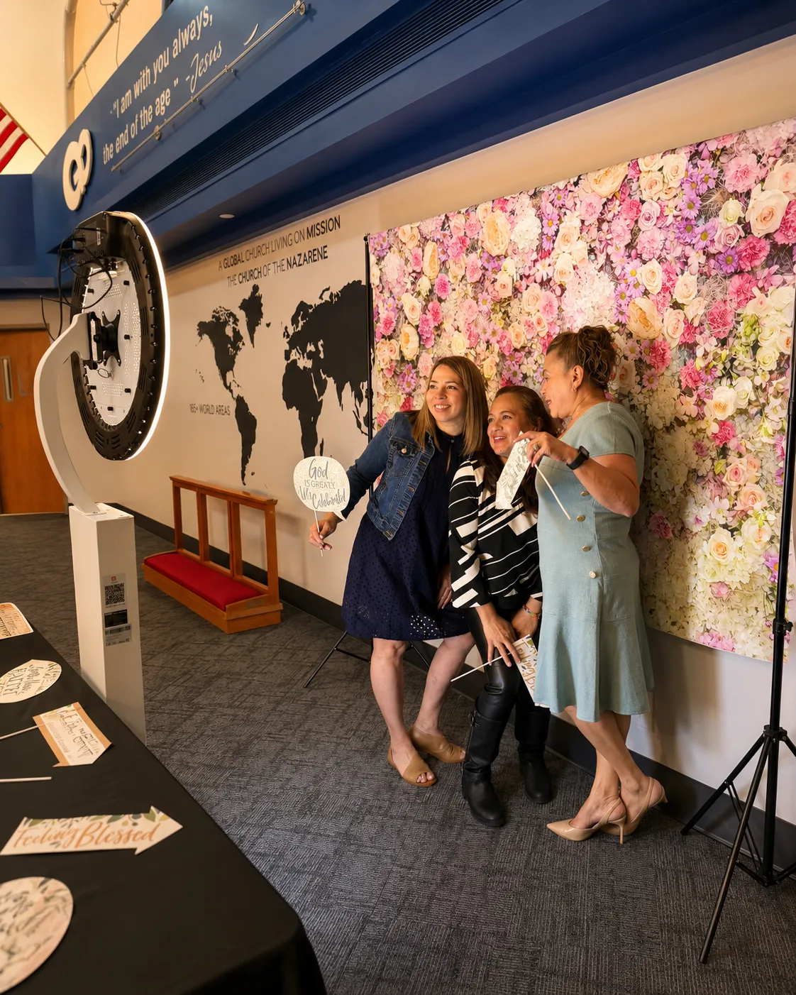 Three friends posing at the floral flower wall